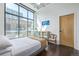 Bright bedroom with large windows, hardwood floors, ceiling fan, and a mirrored vanity at 3100 Huron St # 2D, Denver, CO 80202
