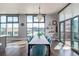Open dining room featuring large windows, floating shelves, and seamless access to a private balcony at 3100 Huron St # 2D, Denver, CO 80202