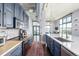 A modern kitchen with stainless steel appliances, butcher block countertops, and blue cabinets with an island at 3100 Huron St # 2D, Denver, CO 80202