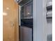 Stacked washer and dryer next to a wood-paneled door and stacked towels at 3100 Huron St # 2D, Denver, CO 80202