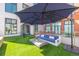 Outdoor patio with a blue umbrella, seating, and artificial turf at 3100 Huron St # 2D, Denver, CO 80202