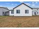 The backyard of this white home has black window trim and ample space for future landscaping at 14390 Heritage Dr, Mead, CO 80504
