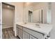 Bathroom features a double sink vanity with a large mirror and wood look flooring at 14390 Heritage Dr, Mead, CO 80504