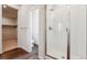 Modern bathroom with glass shower doors, white tile, and contrasting wood-style floor at 14390 Heritage Dr, Mead, CO 80504
