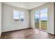 Bedroom featuring hardwood floors, a large window, and access to a private backyard at 14390 Heritage Dr, Mead, CO 80504