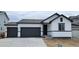 Modern home with a white exterior, dark trim, two-car garage, and a well-maintained front yard at 14390 Heritage Dr, Mead, CO 80504