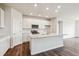 Modern kitchen with white cabinets, stainless steel appliances, and a central island with quartz countertop at 14390 Heritage Dr, Mead, CO 80504