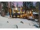 Modern home with a deck, hot tub, and surrounded by trees, set against a snowy landscape and twilight sky at 1290 S Lininger Dr, Golden, CO 80401