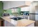 Updated kitchen with stainless steel appliances, granite countertops, and green accent wall at 6251 Willow Ln, Boulder, CO 80301