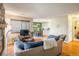 Bright living room with hardwood floors, stone fireplace, and an open layout to the kitchen at 6251 Willow Ln, Boulder, CO 80301