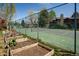 Community tennis court with garden beds, chain link fence, and surrounding landscaping at 6251 Willow Ln, Boulder, CO 80301
