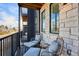 Cozy balcony with stone wall detail, two chairs, and a small table for outdoor relaxation at 5128 W 26Th Ave # 207, Denver, CO 80212