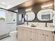 Modern bathroom with double vanity, sleek mirrors, and glass-enclosed shower at 5128 W 26Th Ave # 207, Denver, CO 80212