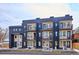 Modern condo building with stone accents, black trim, balconies, and well-maintained landscaping at 5128 W 26Th Ave # 207, Denver, CO 80212