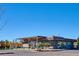 A Shake Shack restaurant exterior with a modern design, outdoor seating, and ample parking under a bright sky at 5128 W 26Th Ave # 207, Denver, CO 80212