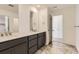 Bathroom featuring a double vanity, marble-style tile floors, and a large rectangular mirror at 39876 Floyd St, Elizabeth, CO 80107