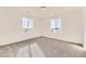 Well-lit bedroom with neutral carpet, white walls, and two large windows at 39876 Floyd St, Elizabeth, CO 80107