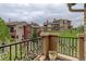 Balcony view of townhouses with manicured lawns, featuring black wrought iron railings and a potted flower arrangement at 9592 Firenze Way, Highlands Ranch, CO 80126