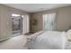 Bright bedroom featuring a sliding glass door to a balcony, neutral tones, and natural light from two large windows at 9592 Firenze Way, Highlands Ranch, CO 80126