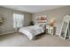 Cozy bedroom with neutral tones, decorative pillows, a full-length mirror, and natural light from the large window at 9592 Firenze Way, Highlands Ranch, CO 80126