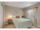 Comfortable bedroom with neutral tones, a side table with lamp, window with blinds and a closet with sliding doors at 9592 Firenze Way, Highlands Ranch, CO 80126