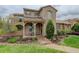 Beautiful home with stone accents, a cozy front porch, and a well-maintained lawn with mature landscaping at 9592 Firenze Way, Highlands Ranch, CO 80126