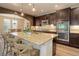 Modern kitchen with dark cabinets, granite counters, a large island with seating, and stainless steel appliances at 9592 Firenze Way, Highlands Ranch, CO 80126