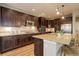 Well-equipped kitchen features stainless steel appliances, dark wood cabinetry, and spacious granite countertops at 9592 Firenze Way, Highlands Ranch, CO 80126