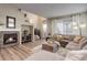 Open-concept living room with a fireplace, wood floors, and staircase, creating a warm and inviting atmosphere at 9592 Firenze Way, Highlands Ranch, CO 80126