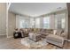 Bright and spacious living room with large windows, hardwood floors, and comfortable seating area with plush, neutral colors at 9592 Firenze Way, Highlands Ranch, CO 80126