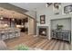 Cozy living room with fireplace flowing into the kitchen, featuring hardwood floors and an open-concept design at 9592 Firenze Way, Highlands Ranch, CO 80126