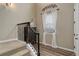 Elegant staircase with wrought iron railing and a large window with natural light and decorative accents at 9592 Firenze Way, Highlands Ranch, CO 80126