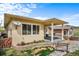 Charming backyard with covered patio, lovely landscaping, and decorative stone creek at 17670 W 94Th Dr, Arvada, CO 80007