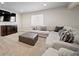 Cozy basement living area with plush sectional sofa, entertainment center, and modern decor at 17670 W 94Th Dr, Arvada, CO 80007