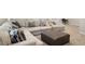 Close-up on finished basement living area with a sectional sofa and tufted ottoman at 17670 W 94Th Dr, Arvada, CO 80007