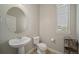 Half bathroom with pedestal sink, toilet and window at 17670 W 94Th Dr, Arvada, CO 80007