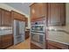 Close up of the kitchen stainless refrigerator, double oven, and granite countertop at 17670 W 94Th Dr, Arvada, CO 80007
