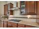 Close-up of the kitchen stove, backsplash, counter and dark wood cabinets at 17670 W 94Th Dr, Arvada, CO 80007
