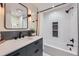 Modern bathroom with a sleek vanity, bathtub with shower, and tiled walls, for a refreshing experience at 13211 W 32Nd Ave, Golden, CO 80401