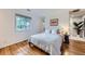 Cozy bedroom with hardwood floors, large window, and access to the bathroom at 13211 W 32Nd Ave, Golden, CO 80401