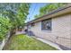 View of the backyard featuring a brick house with greenery and mature trees at 13211 W 32Nd Ave, Golden, CO 80401