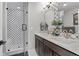 Stylish bathroom with a glass door shower, patterned tile, and a double sink vanity with bronze hardware at 4072 W 17Th Ave, Denver, CO 80204