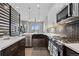 Modern kitchen with island, stainless appliances, stylish backsplash, and hardwood floors at 4072 W 17Th Ave, Denver, CO 80204