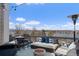 Relaxing rooftop deck with plush seating, fire pit, and panoramic views of the lake and blue skies at 4072 W 17Th Ave, Denver, CO 80204