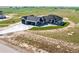 Aerial view of new home showing lawn, landscaping, and oversized driveway at 56520 E 74Th Ave, Strasburg, CO 80136