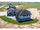 New home aerial showcases the modern design and a well-manicured lawn at 56520 E 74Th Ave, Strasburg, CO 80136