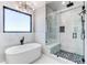 Modern bathroom with a soaking tub, a glass-enclosed shower, and elegant fixtures at 56520 E 74Th Ave, Strasburg, CO 80136