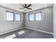 Serene bedroom features plush carpeting, three large windows, and a modern ceiling fan at 56520 E 74Th Ave, Strasburg, CO 80136