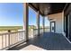 Back deck featuring wood flooring, white railings and posts with views of the community at 56520 E 74Th Ave, Strasburg, CO 80136