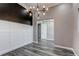 Entry room features dark accent wall with white wainscotting, gray floor, and modern light fixture at 56520 E 74Th Ave, Strasburg, CO 80136